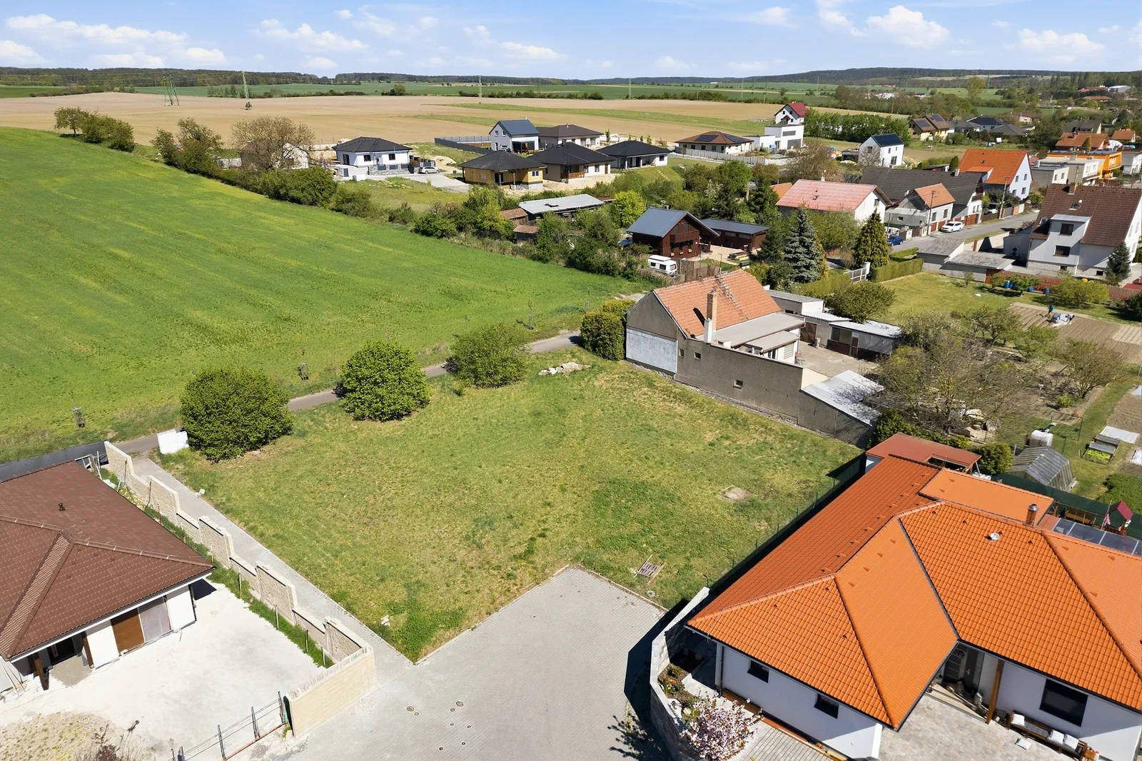 Pozemek mezi novostavbami s otevřenou krajinou